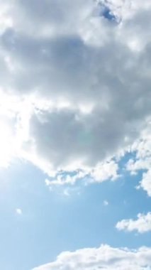 Mavi gökyüzü, yumuşak beyaz bulutlar ve güneş. Soyut zaman dilimi, bulutlu gökyüzü