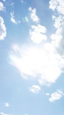 Mavi gökyüzü, yumuşak beyaz bulutlar ve güneş. Soyut zaman dilimi, bulutlu gökyüzü