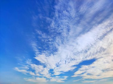 Pofuduk beyaz bulutlu parlak mavi gökyüzü. Güneş ışığıyla aydınlatılan yumuşak bulut şekilli doğal bir arka plan. Hava, doğa ve manzara temaları için mükemmel
