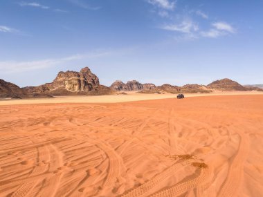 A black 4x4 truck driving away in the middle of the desert