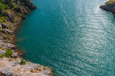 Su barajı ve baraj nehri mavi bulutlu gökyüzünün altındaki yeşil dağlar arasında.