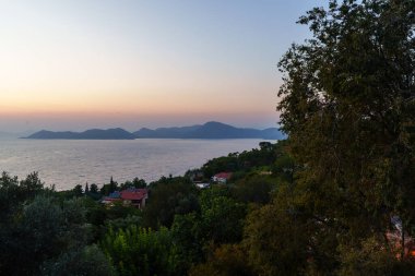 Altın saat günbatımında ahşap bir verandadan deniz ve okyanus manzarası