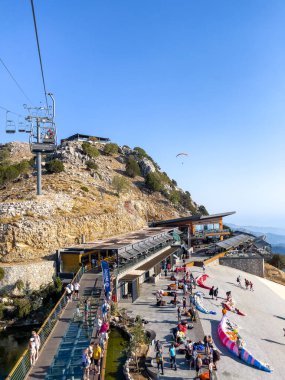Bir grup yamaç paraşütçüsü sergilenen macera ve özgürlüğün sergilendiği açık bir günde çarpıcı bir dağ manzarasında keyifli bir uçuşun tadını çıkarıyor..