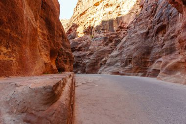 Canlı doğal renklere ve dokulara sahip yüksek kaya oluşumlarının yer aldığı manzaralı bir çöl geçidi..
