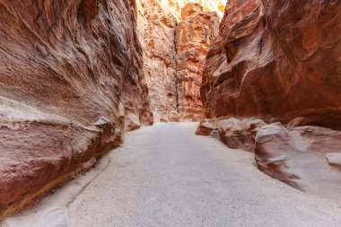 A scenic desert passage featuring towering rock formations with vibrant natural hues and textures. clipart