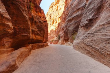 Canlı doğal renklere ve dokulara sahip yüksek kaya oluşumlarının yer aldığı manzaralı bir çöl geçidi..