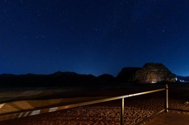 Yıldızlarla aydınlatılmış bir çöl göğünün altında aydınlık kubbeler huzurlu ve maceralı bir kamp ortamı yaratıyor..