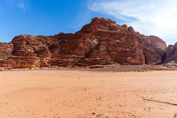 Geniş çöl manzaraları parlak mavi gökyüzü altında kayalık oluşumlar sergiliyor. Huzur ve yalnızlık yayıyor, Wadi Rum Jordan.