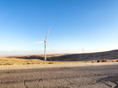 Wind Turbines on a Serene Landscape Under Clear Blue Sky clipart