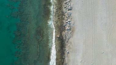 Temiz bir turkuaz deniz ve kumlu plajın üzerinde havadan 4k görüntüsü. Antalya, Türkiye