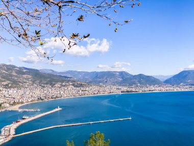 Canlı bir limanı, etrafındaki dağları ve açık mavi gökyüzünü barındıran manzaralı bir sahil şehri. Seyahat ilhamları ve Akdeniz atmosferlerinin sergilenmesi için ideal.