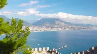 Iconic Alanya Limanı Panorama İskele ve Deniz fenerinin Antik Kale Duvarları Çerçeveli Çekimi (4K Drone View)