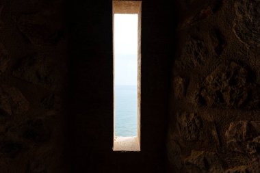 Işığın bir delikten aktığı sönük ışıklı antik taş koridor.