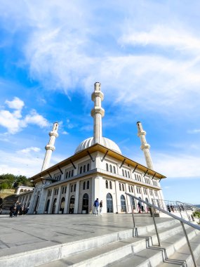 Güneş ışığıyla aydınlatılan bulutlu mavi gökyüzünün altında muhteşem bir cami.