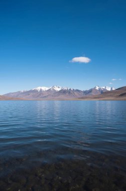 Dağları ve mavi gökyüzü olan güzel bir manzara.