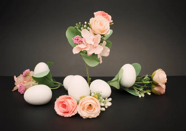 Pastel flowers with white easter eggs on the dark background