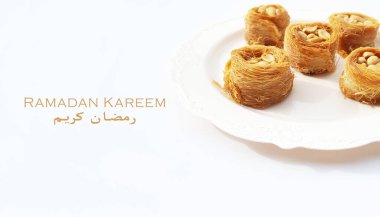 Ramazan Kareem, beyaz bir tabakta yuvarlak bir baklava ve beyaz bir arka planla kutsadı.