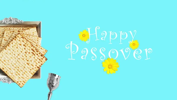 Matza in a silver plate, with a silver cup for Kiddush and yellow flowers. Passover elements for a blessing and a greeting card. top view of matza,jewish Passover Pesach, Happy holiday