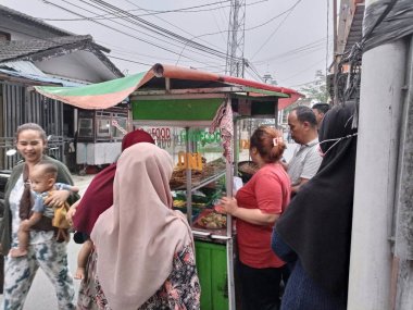 Kızarmış tavuk, ciğer, taşlık satıcıları sırada bekleyen müşterilere hizmet ediyorlar.