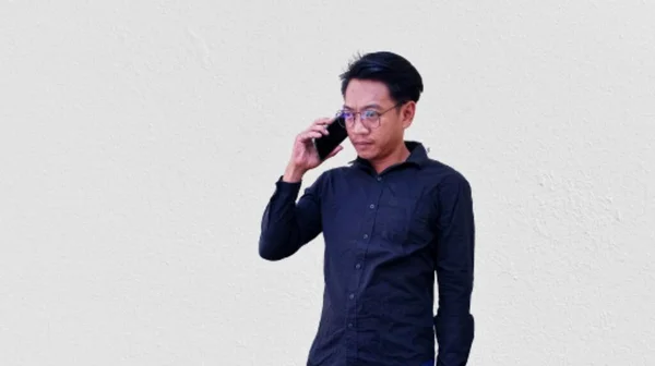 Retrato Homem Asiático Confuso Vestindo Camisa Preta Segurando Seu Telefone — Fotografia de Stock