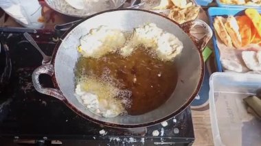 Patates kızartması kızartması kızartma makinesine dönüşüyor. Çıtır patatesler mutfakta kızgın yağda kızartılıyor. Mutfakta fast food hazırlama süreci. Yemek hazırlama konsepti. Üst Görünüm Yavaş Çekim