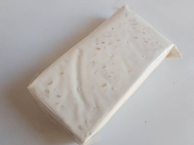 Tempe ya da tempeh beyaz plastiğe sarılmış geleneksel Endonezya yemekleri. Mayalanmış soya fasulyesinden yapılmış. İzole edilmiş beyaz arka plan.