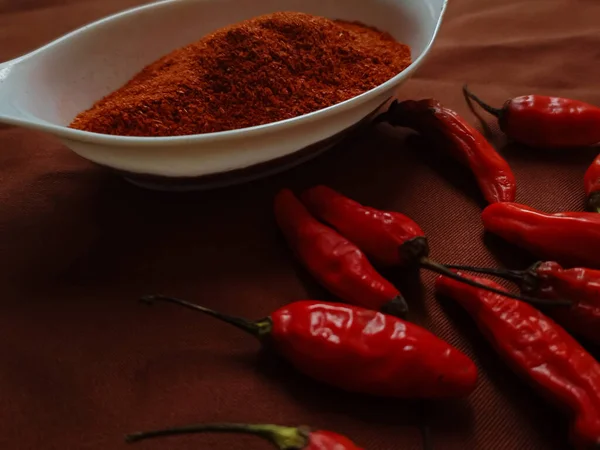辣椒粉是一种调味的调料 将磨碎的辣椒混合在一个白色的碗里 红色的辣椒在褐色的背景上 — 图库照片