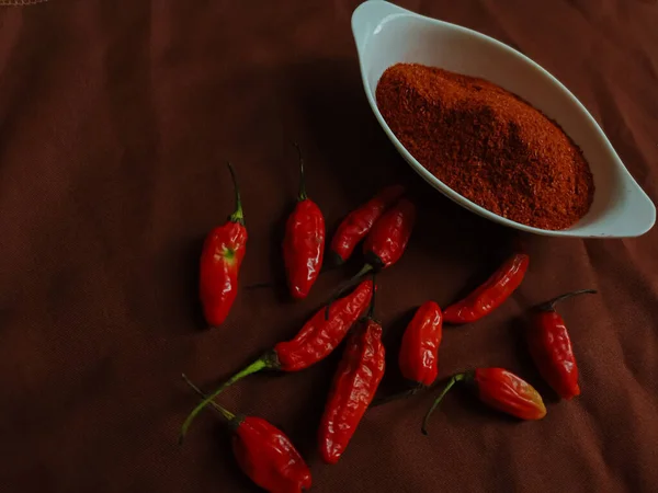 辣椒粉是一种调味的调料 将磨碎的辣椒混合在一个白色的碗里 红色的辣椒在褐色的背景上 — 图库照片
