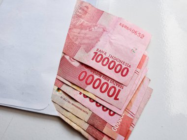 Endonezya parası, rupiah veya IDR zarf içinde. THR zarfında 100.000 dolar nakit para var. THR, Kurban Bayramı ya da Kurban Bayramı için verilen bir tatil parasıdır. en kaliteli beyaz arkaplan.