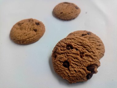 yuvarlak çikolatalı kekler ve kremayla dolu pastalar izole edilmiş, beyaz bir arka planda..