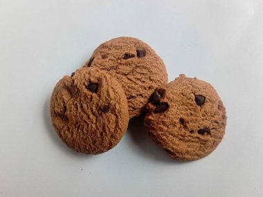 yuvarlak çikolatalı kekler ve kremayla dolu pastalar izole edilmiş, beyaz bir arka planda..