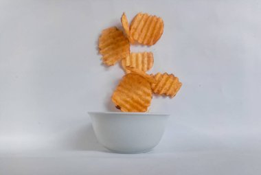 Lezzetli patates cipsi darbe beyaz zemin üzerine düşen
