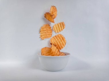 Lezzetli patates cipsi darbe beyaz zemin üzerine düşen