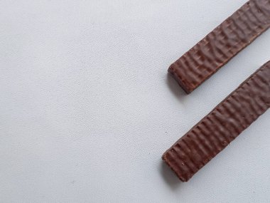 Beyaz arka planda lezzetli çikolata kaplı protein çubukları. Sağlıklı çerez