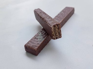 Beyaz arka planda lezzetli çikolata kaplı protein çubukları. Sağlıklı çerez