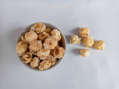 Beyaz arka planda izole edilmiş kasedeki lezzetli peynirli patlamış mısır. Duvar kağıdı, afiş, metin için kopya alanı olan başlık. Fast food, sinema, sinema ve eğlence konsepti.