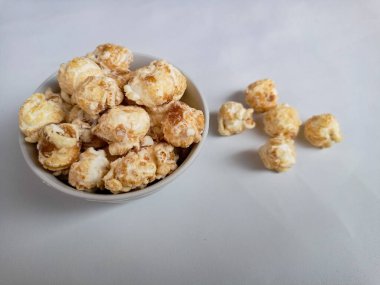 Beyaz arka planda izole edilmiş kasedeki lezzetli peynirli patlamış mısır. Duvar kağıdı, afiş, metin için kopya alanı olan başlık. Fast food, sinema, sinema ve eğlence konsepti.