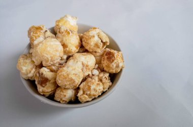 Beyaz arka planda izole edilmiş kasedeki lezzetli peynirli patlamış mısır. Duvar kağıdı, afiş, metin için kopya alanı olan başlık. Fast food, sinema, sinema ve eğlence konsepti.