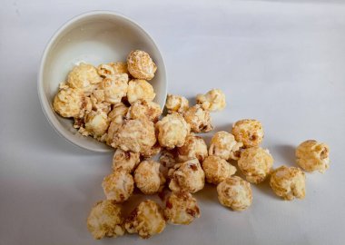 Beyaz arka planda izole edilmiş kasedeki lezzetli peynirli patlamış mısır. Duvar kağıdı, afiş, metin için kopya alanı olan başlık. Fast food, sinema, sinema ve eğlence konsepti.