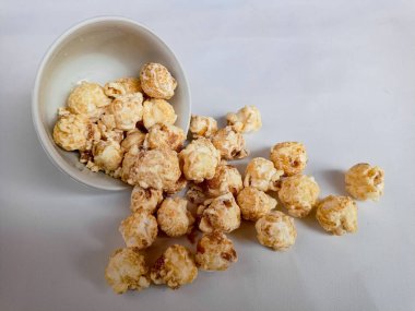 Beyaz arka planda izole edilmiş kasedeki lezzetli peynirli patlamış mısır. Duvar kağıdı, afiş, metin için kopya alanı olan başlık. Fast food, sinema, sinema ve eğlence konsepti.