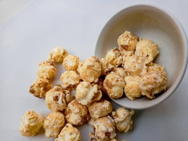 Beyaz arka planda izole edilmiş kasedeki lezzetli peynirli patlamış mısır. Duvar kağıdı, afiş, metin için kopya alanı olan başlık. Fast food, sinema, sinema ve eğlence konsepti.