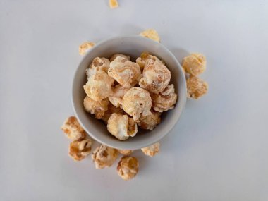 Beyaz arka planda izole edilmiş kasedeki lezzetli peynirli patlamış mısır. Duvar kağıdı, afiş, metin için kopya alanı olan başlık. Fast food, sinema, sinema ve eğlence konsepti.