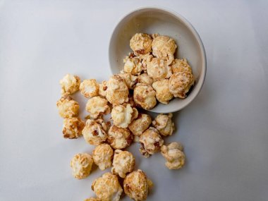 Beyaz arka planda izole edilmiş kasedeki lezzetli peynirli patlamış mısır. Duvar kağıdı, afiş, metin için kopya alanı olan başlık. Fast food, sinema, sinema ve eğlence konsepti.