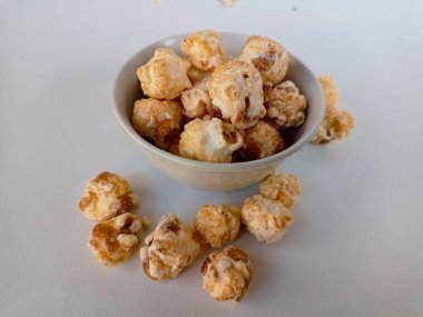 Beyaz arka planda izole edilmiş kasedeki lezzetli peynirli patlamış mısır. Duvar kağıdı, afiş, metin için kopya alanı olan başlık. Fast food, sinema, sinema ve eğlence konsepti.