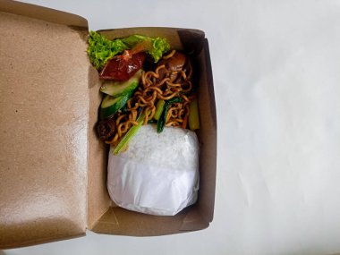 Pirinç, erişte, sebze ve çevre dostu ambalaj kağıdıyla birlikte Endonezya sefertası..