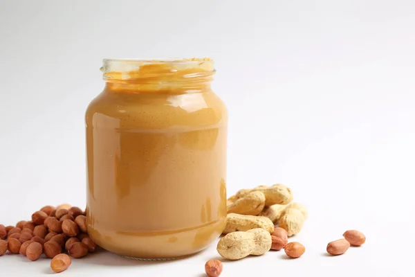 stock image peanut butter and raw peanuts on a light background. High quality photo