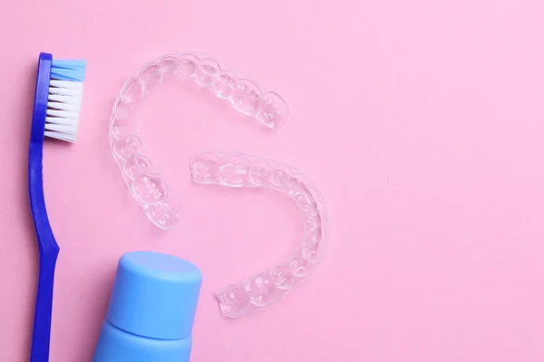 Renkli bir arka planda şeffaf plastik diş hizalayıcıları ve bakım ürünleri. Yüksek kalite fotoğraf