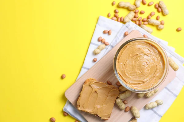 stock image peanut butter and raw peanuts on a colored background. High quality photo