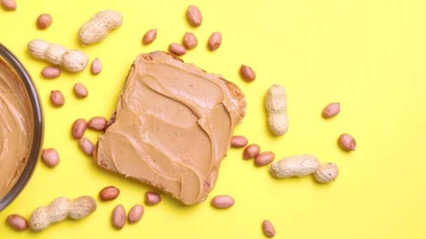 Erdnussbutter Und Rohe Erdnüsse Auf Farbigem Hintergrund Hochwertiges Foto — Stockvideo