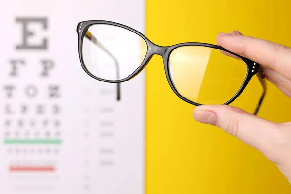 Sehkorrekturbrille Der Hand Vor Dem Hintergrund Eines Sehtesttisches Mit Platz — Stockfoto